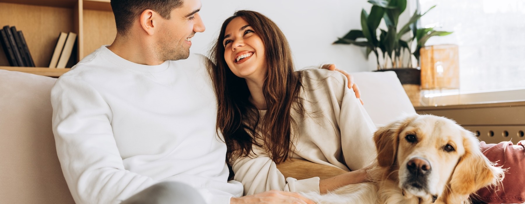 a man and woman sitting on a couch with a dog
